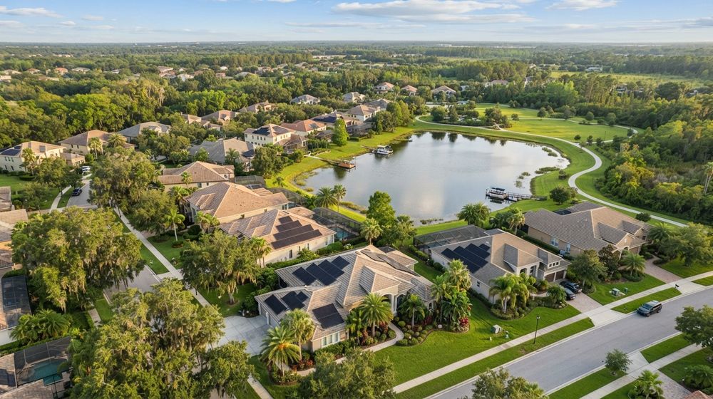 Aerial view of a Central Florida suburban neighborhood with a small lake and rooftop solar panels